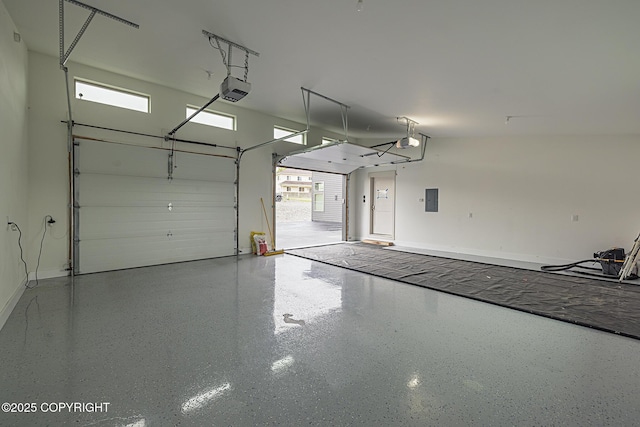 9475 E Spring Creek Cir, Wasilla, AK 99654 - garage featuring electric panel, a garage door opener, and baseboards