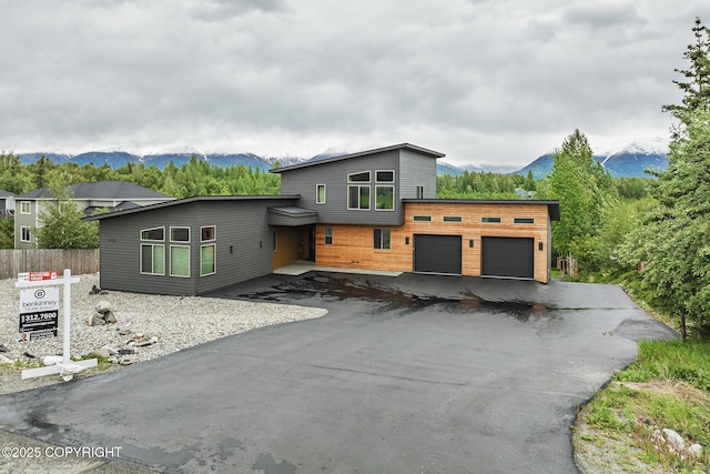 9475 E Spring Creek Cir, Wasilla, AK 99654 - modern home featuring a garage, a mountain view, and asphalt driveway