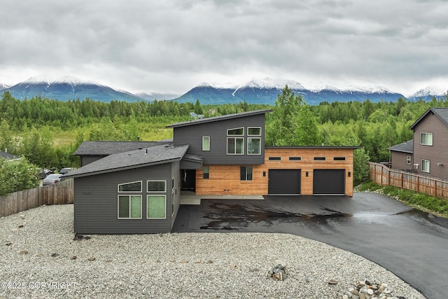 9475 E Spring Creek Cir, Wasilla, AK 99654 - contemporary house with a mountain view, a garage, asphalt driveway, and a wooded view