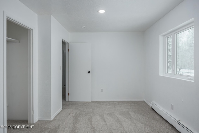 unfurnished bedroom with recessed lighting, a baseboard heating unit, carpet floors, and baseboards