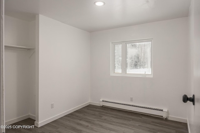 unfurnished bedroom with recessed lighting, a baseboard radiator, baseboards, and wood finished floors