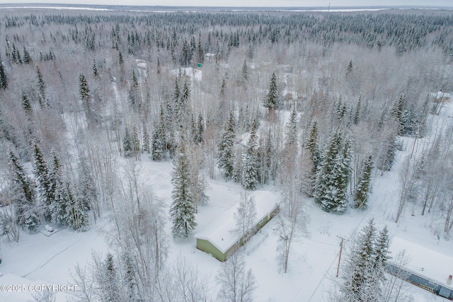 snowy aerial view with a wooded view