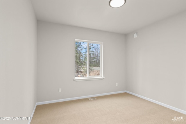 empty room featuring visible vents, light carpet, and baseboards