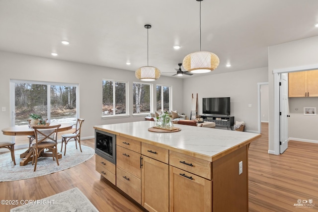 kitchen featuring built in microwave, recessed lighting, light wood-style flooring, and light countertops