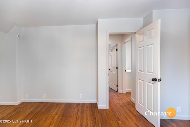 unfurnished room with wood finished floors and baseboards