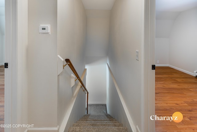 stairway with vaulted ceiling, baseboards, and wood finished floors