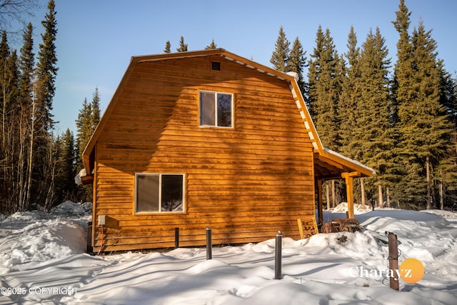 view of snowy exterior with a gambrel roof