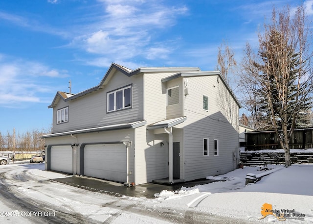 view of snowy exterior featuring a garage