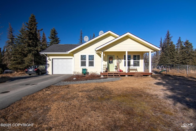 view of front facade with a garage, fence, covered porch, and driveway