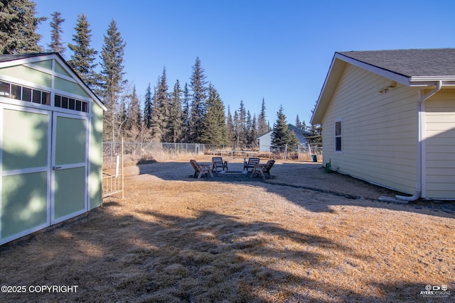 view of yard featuring an outdoor structure and fence