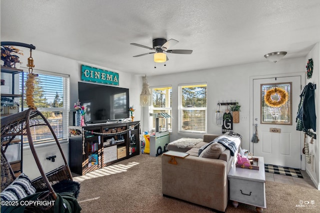 living area featuring carpet flooring, a textured ceiling, a healthy amount of sunlight, and a ceiling fan