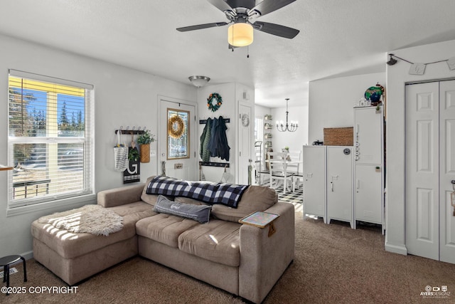 carpeted living room with ceiling fan with notable chandelier, baseboards, and a textured ceiling