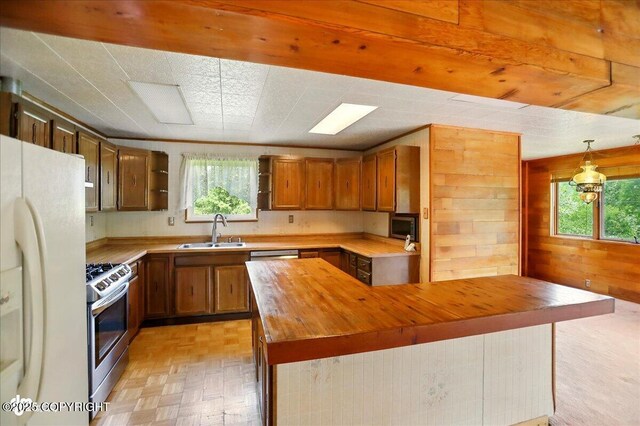 24508 Reese Rd, Chugiak, AK 99567 - kitchen with butcher block counters, a sink, stainless steel range with gas stovetop, freestanding refrigerator, and open shelves