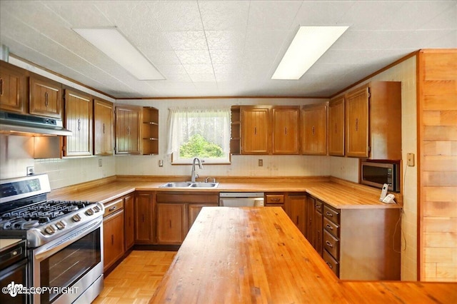 24508 Reese Rd, Chugiak, AK 99567 - kitchen with appliances with stainless steel finishes, a sink, under cabinet range hood, wooden counters, and open shelves