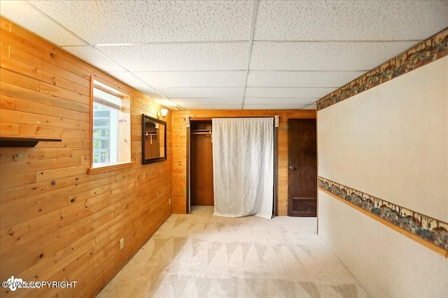 24508 Reese Rd, Chugiak, AK 99567 - unfurnished bedroom with a paneled ceiling, carpet floors, wood walls, and a closet