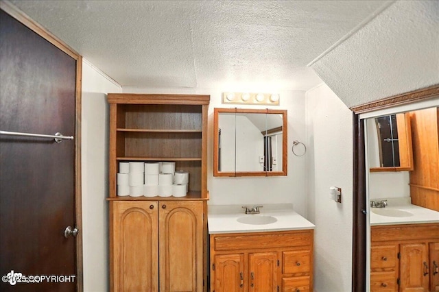24508 Reese Rd, Chugiak, AK 99567 - full bathroom featuring two vanities and a textured ceiling