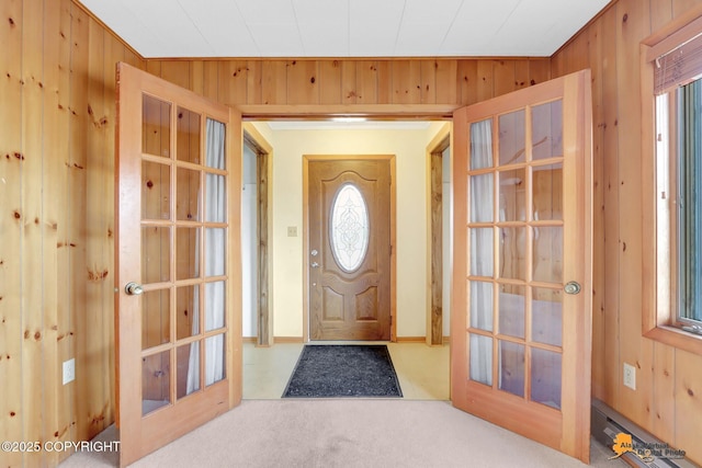 entrance foyer with wood walls and carpet floors