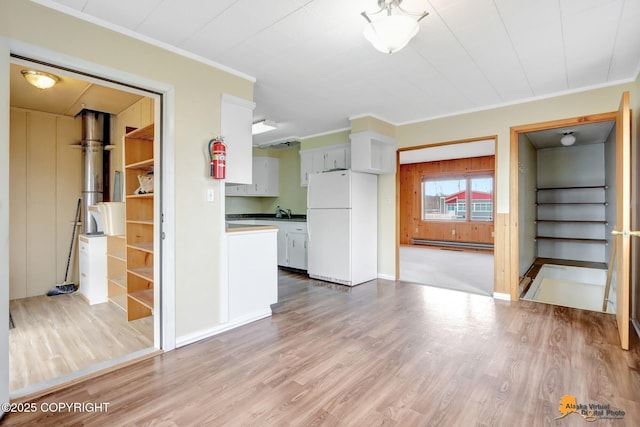 unfurnished living room featuring a baseboard radiator, light wood-style flooring, and ornamental molding