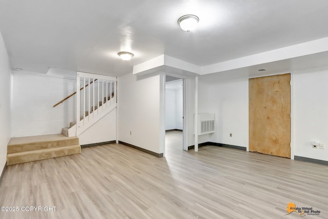 finished basement with stairway, baseboards, visible vents, and wood finished floors