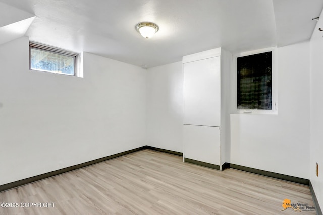 spare room featuring baseboards and light wood-type flooring