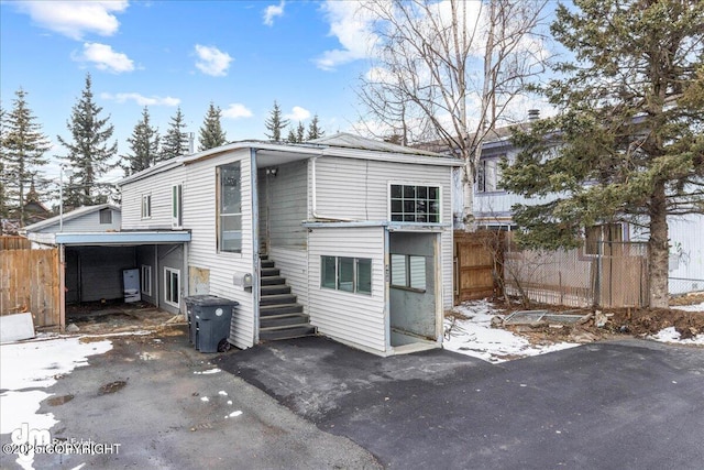 rear view of house with stairs and fence