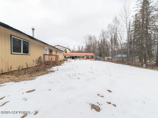 yard layered in snow with a wooden deck