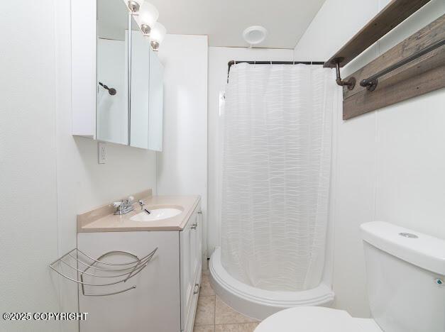 full bath featuring vanity, toilet, a shower stall, and tile patterned flooring