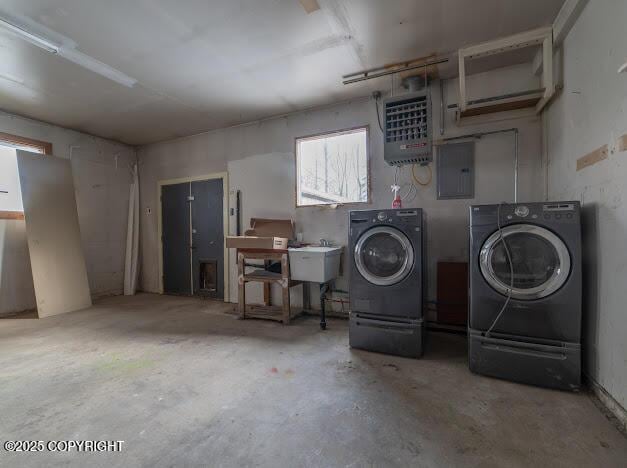 basement with heating unit, electric panel, washing machine and dryer, and a sink