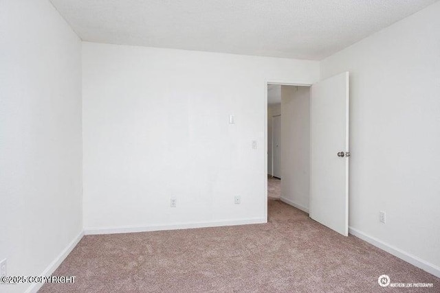 carpeted spare room featuring baseboards