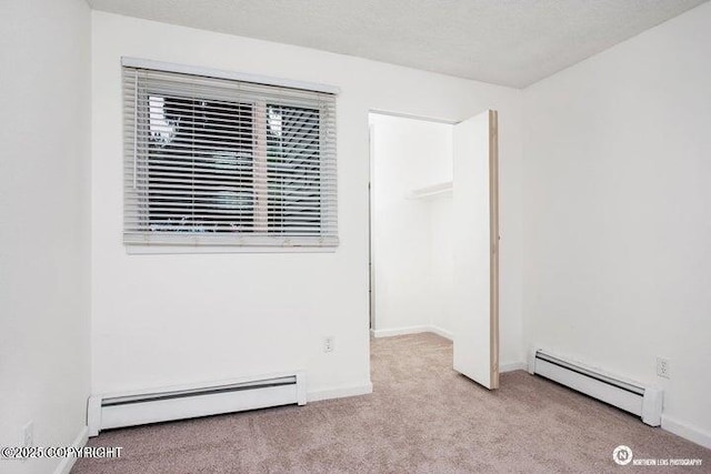 unfurnished bedroom with baseboards, baseboard heating, and carpet floors