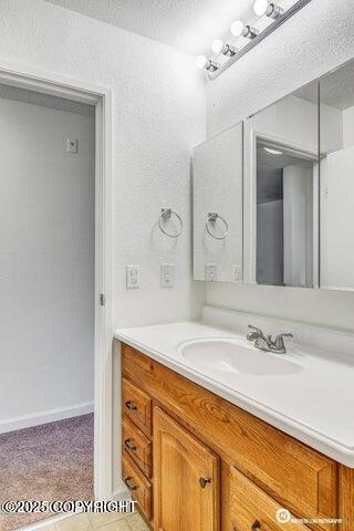 bathroom with a textured ceiling and vanity