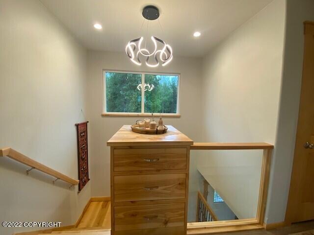 stairs featuring recessed lighting, wood finished floors, and a chandelier