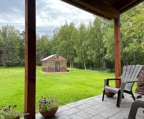 view of patio with an outbuilding and a storage structure