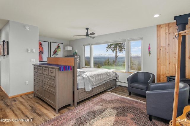 bedroom featuring baseboards, ceiling fan, light wood-type flooring, baseboard heating, and recessed lighting