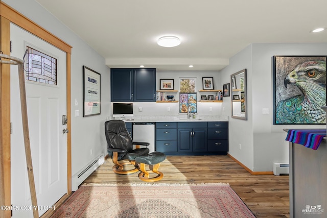 kitchen with light wood-type flooring, a sink, a baseboard heating unit, baseboard heating, and dishwasher