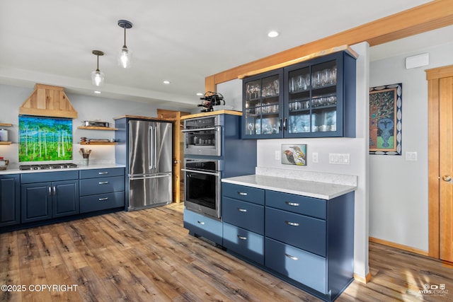 kitchen featuring light countertops, blue cabinets, wood finished floors, and stainless steel appliances