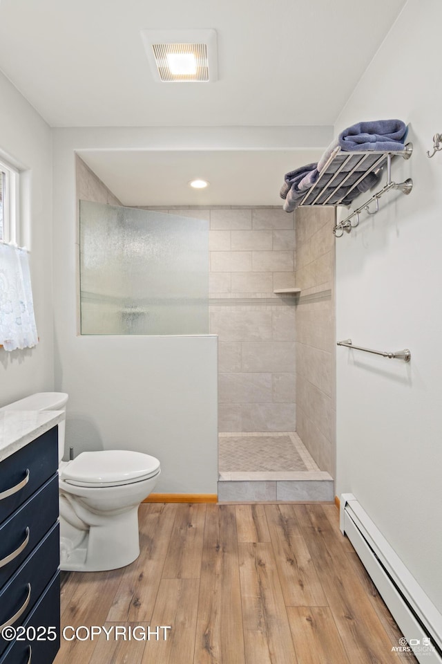 full bathroom featuring visible vents, toilet, wood finished floors, a baseboard radiator, and walk in shower