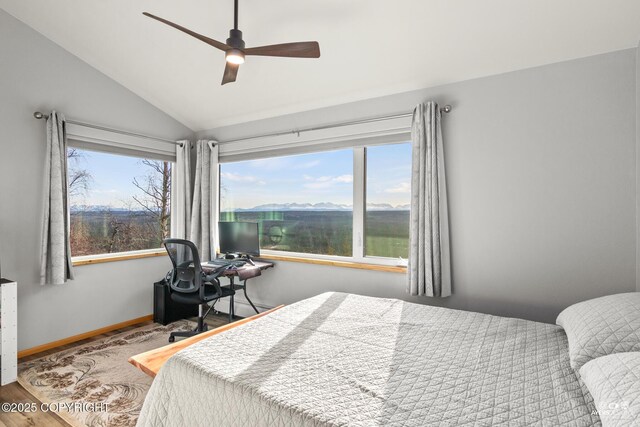 bedroom featuring lofted ceiling, wood finished floors, baseboards, and ceiling fan