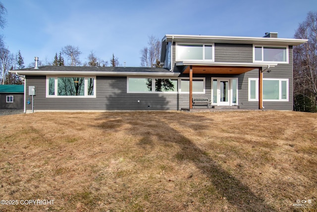 back of property featuring french doors and a lawn