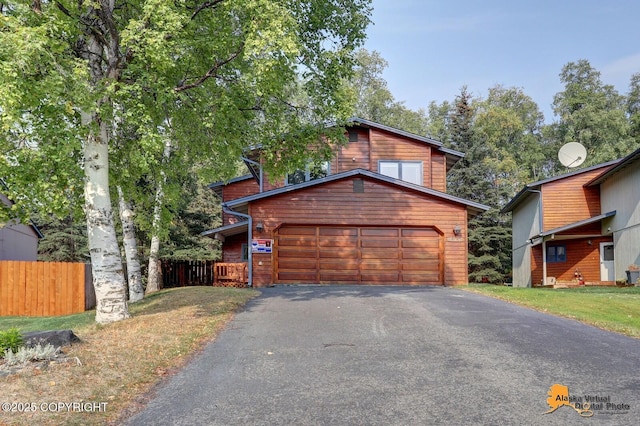 chalet / cabin featuring a front yard, fence, a garage, and driveway