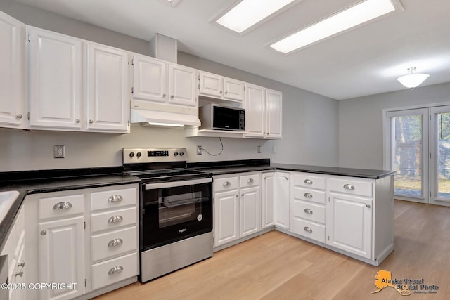 kitchen featuring a peninsula, stainless steel appliances, under cabinet range hood, white cabinetry, and dark countertops