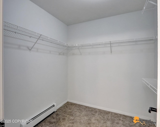 walk in closet with a baseboard heating unit and carpet