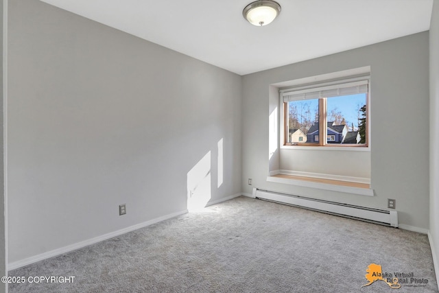 carpeted spare room with baseboard heating and baseboards