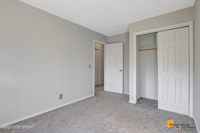 unfurnished bedroom featuring a closet, carpet flooring, and baseboards