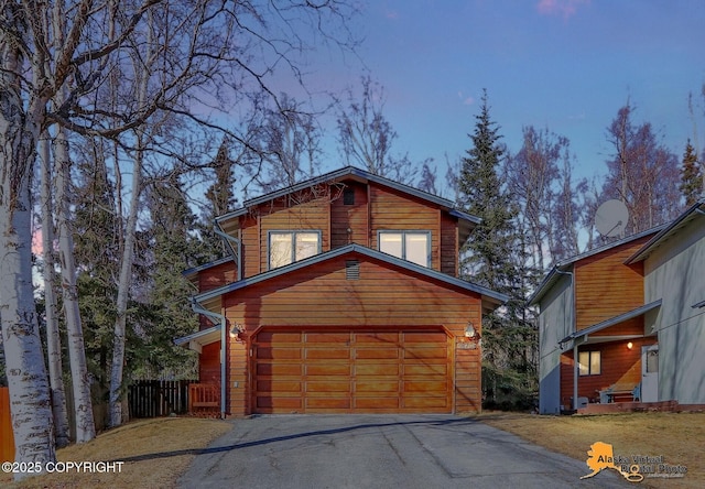 rustic home with a garage and fence