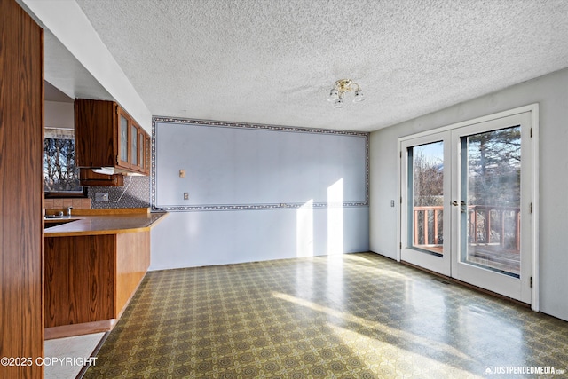 interior space with french doors and a textured ceiling