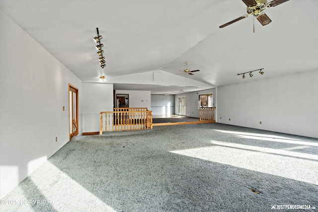 interior space featuring carpet flooring, rail lighting, a ceiling fan, and lofted ceiling