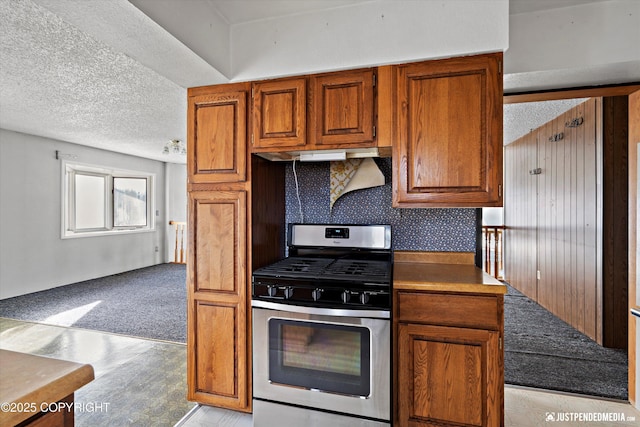 kitchen featuring gas range, a textured ceiling, and brown cabinetry