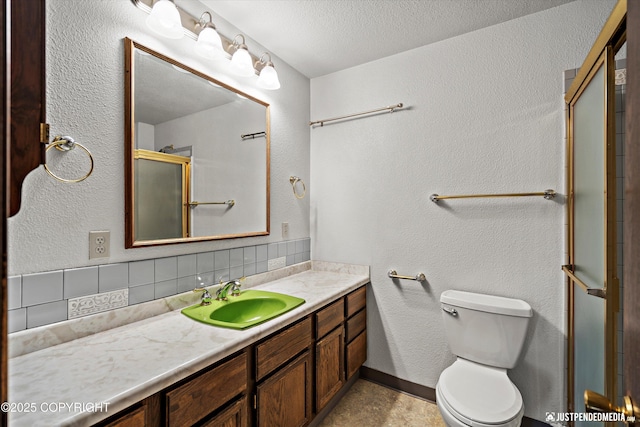 full bath featuring backsplash, toilet, vanity, an enclosed shower, and a textured ceiling