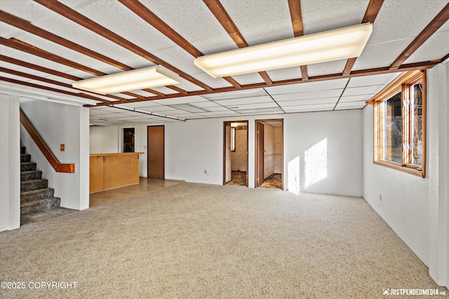 interior space featuring stairs, carpet, and a drop ceiling